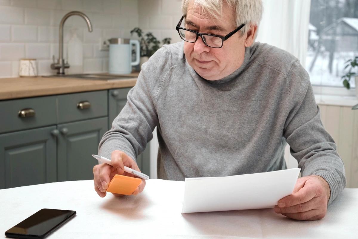 Man holding form looking at phone