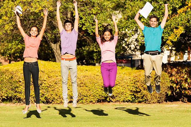 Image of students in a row jumping up celebrating exam success. Where to find free food and drinks for A-Level students on results day 2025