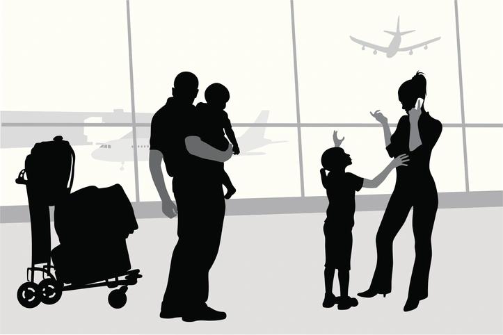Family at airport in black and white, mum on phone