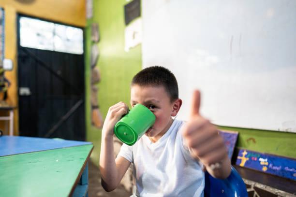 Image of a child at school eating breakfast. Free school breakfast clubs launch today