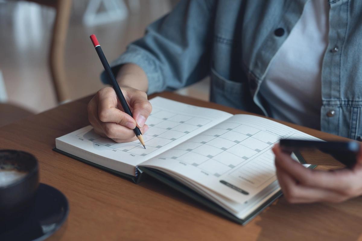 A close-up of someone writing in their diary