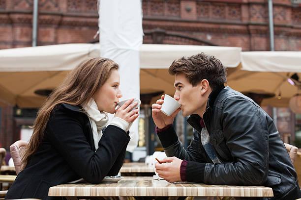 Image of a couple staring into each others eyes drinking a cup of coffee
