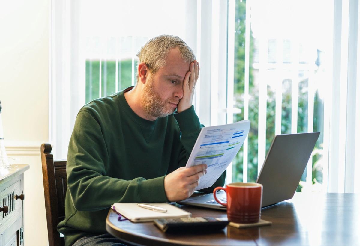 A worried looking man looking at his energy bill