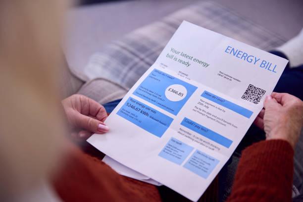 Image of a man reading an energy bill. Energy standing charges to increase from April