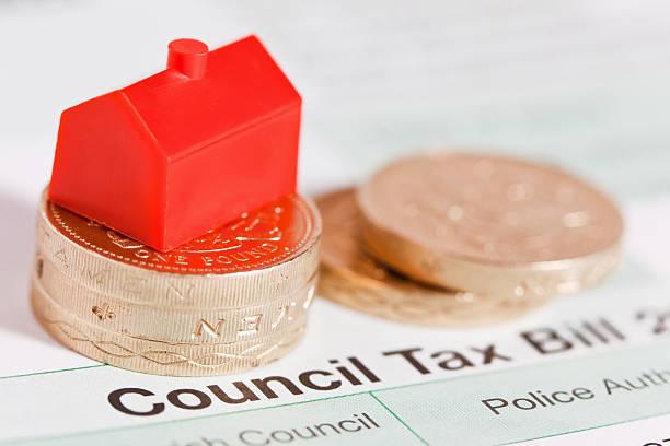 Image of a council tax bill with pound coins on top and a red monopoly house. Find out how much your council tax will increase in April