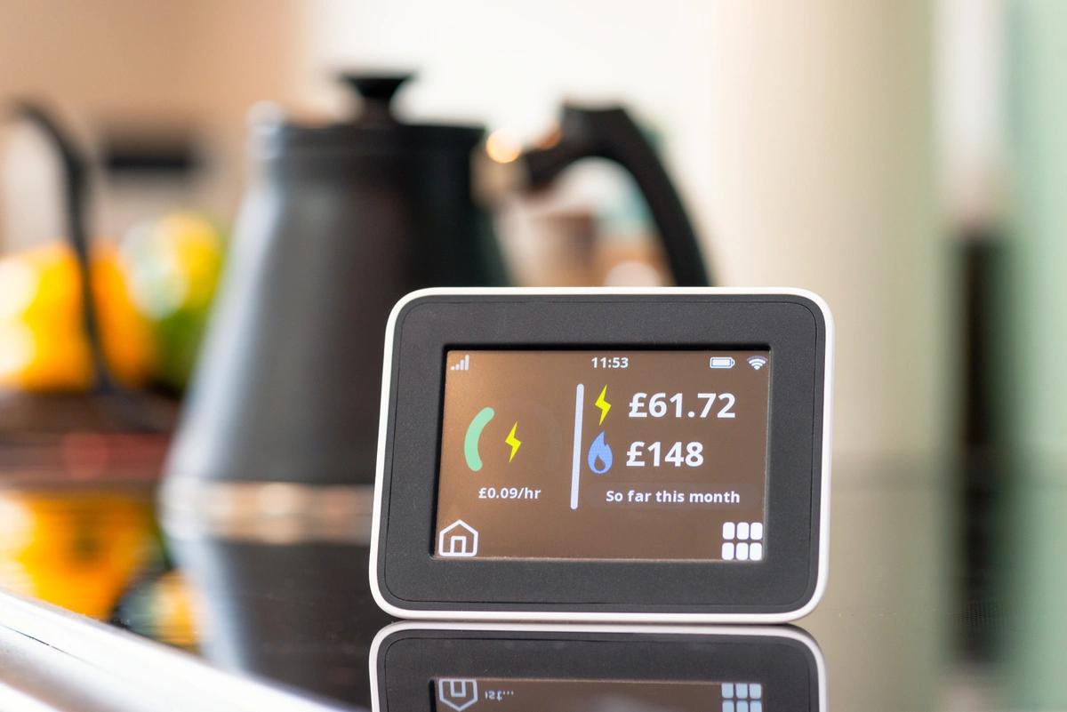 An energy smart meter in front on a kettle