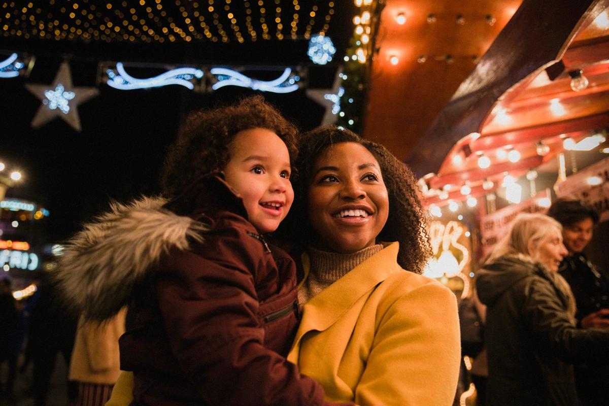 Happy mum and young daughter at a Christmas market