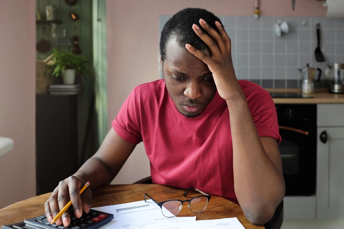 A worried-looking man goes through his finances