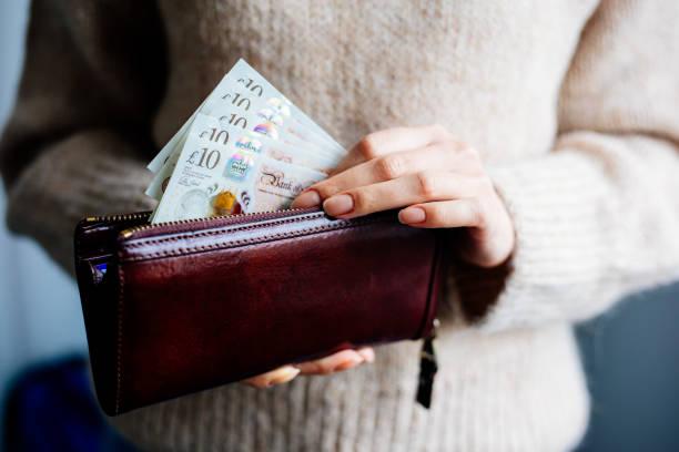 woman counting ten pound notes into her purse