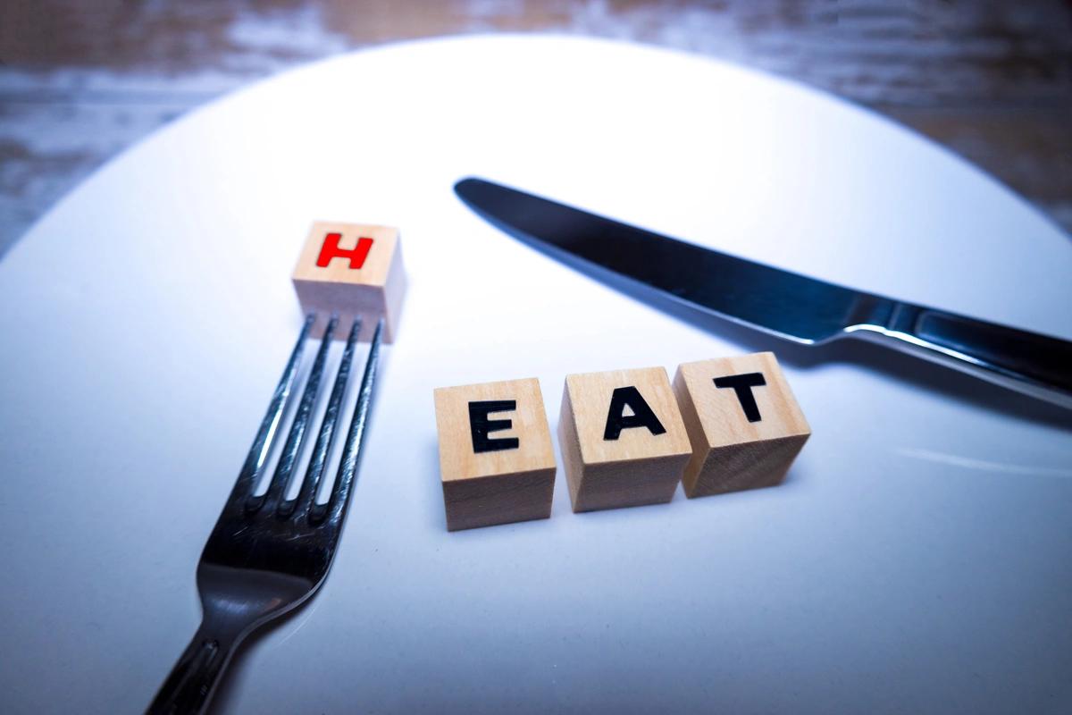 A plate with wooden blocks on it depicting the phrase heat or eat