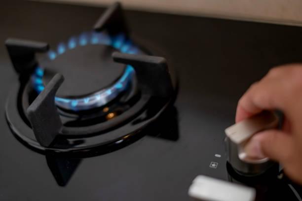 Image of a gas hob being turned on. Ofgem announces energy prices to fall from April. What do you if you have energy debt. Can't afford gas and electricity
