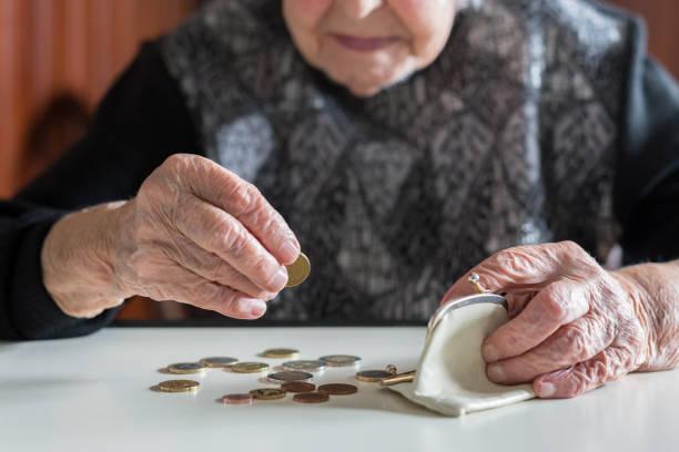 Image shows a pensioner counting coins out of her purse