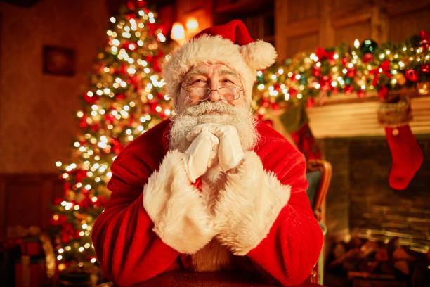 Image of Father Christmas in front of a Christmas tree looking excited