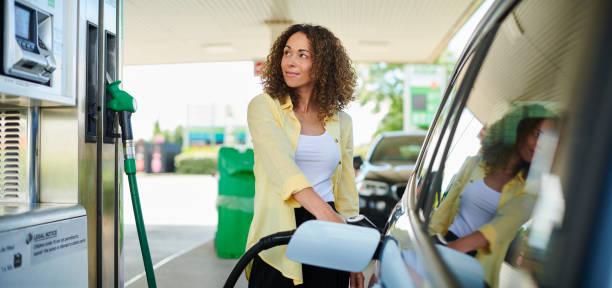 Image of a woman fill up her car at a petrol pump
