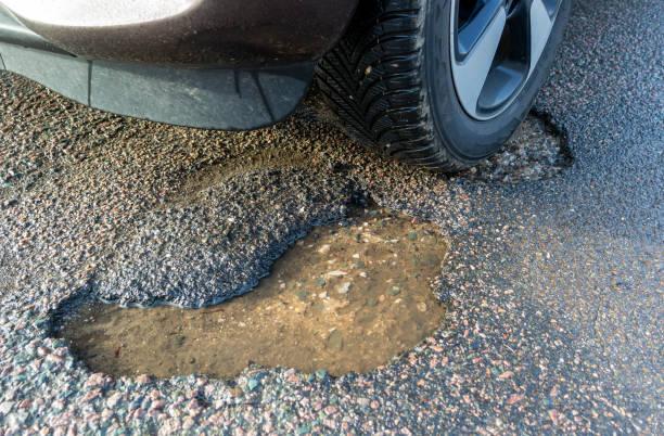Image of a car tyre about to go into a pothole. Pothole damage rising. Find out how to claim compensation