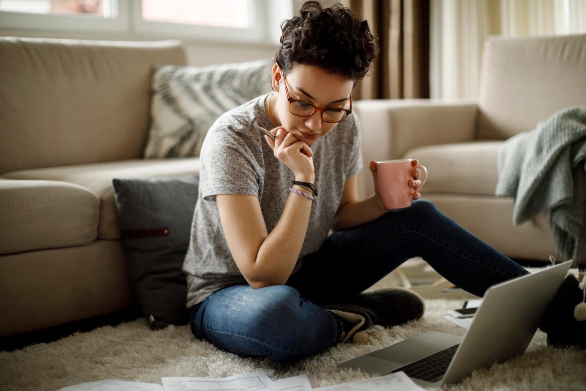 Woman sitting at laptop thinking