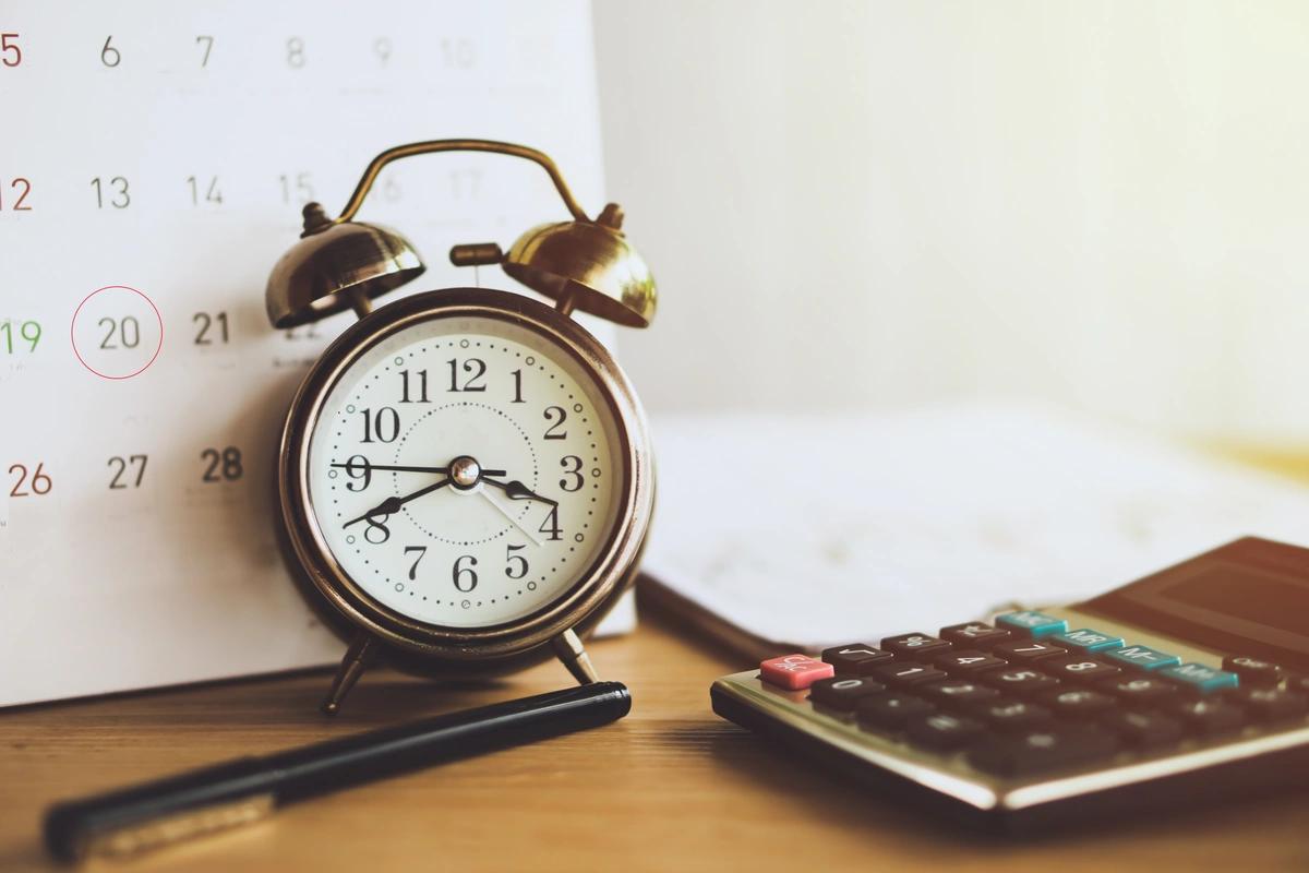 Calculator, calendar and alarm clock sitting on desk