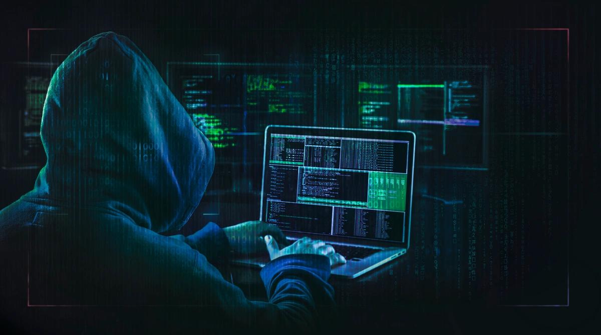 An online hacker at a laptop steals online information