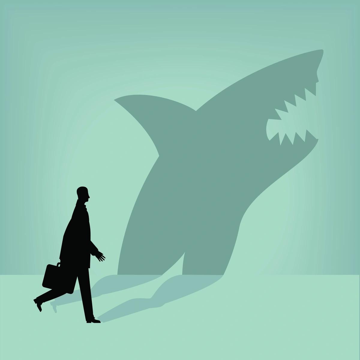 A man with a briefcase with a shark-shaped shadow