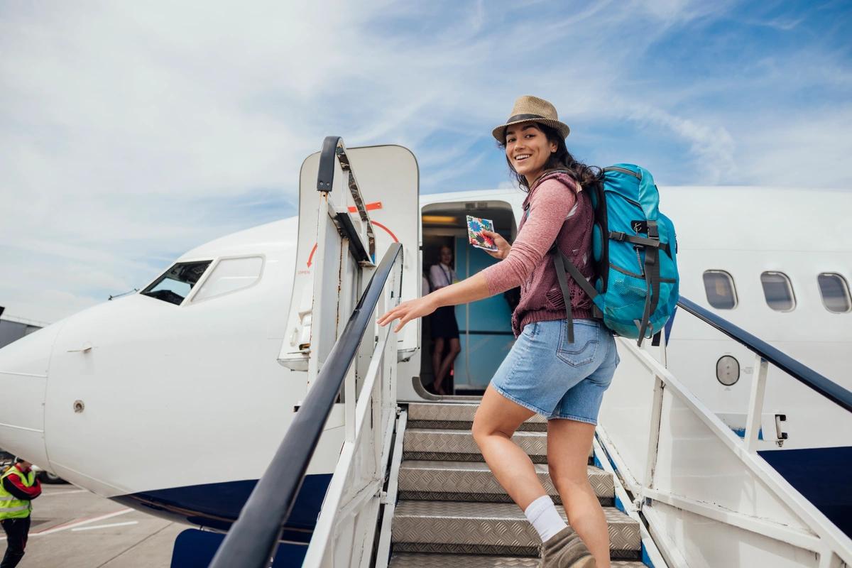 A young woman with a backpack boarding a plane